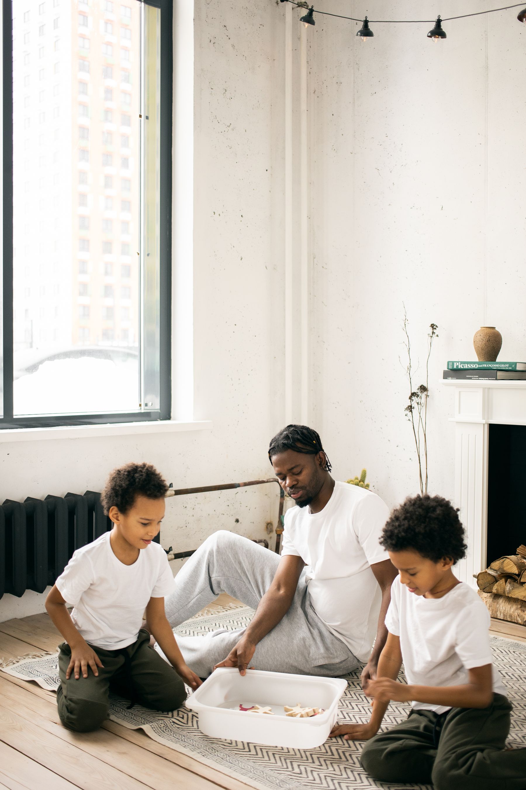A Black father and his children playing together at home