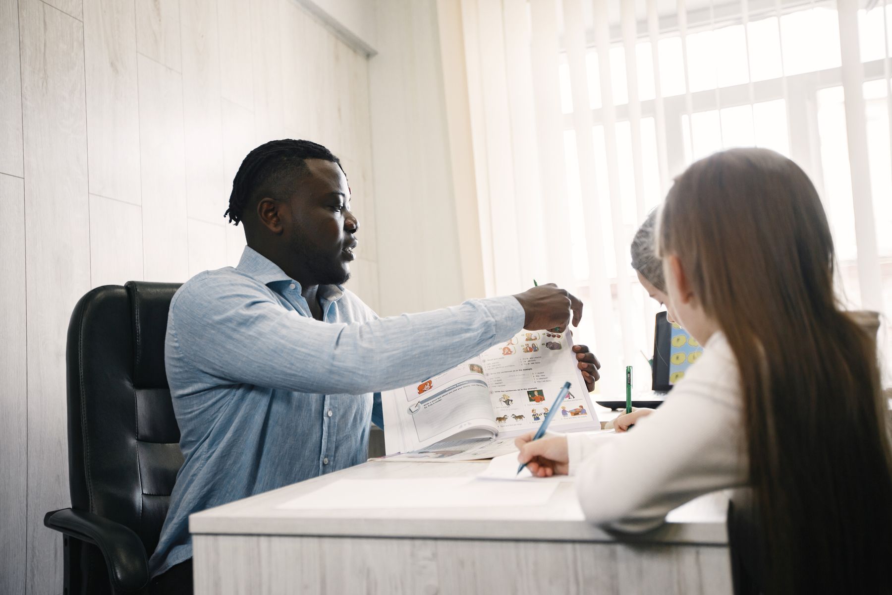 An educator guiding students through schoolwork