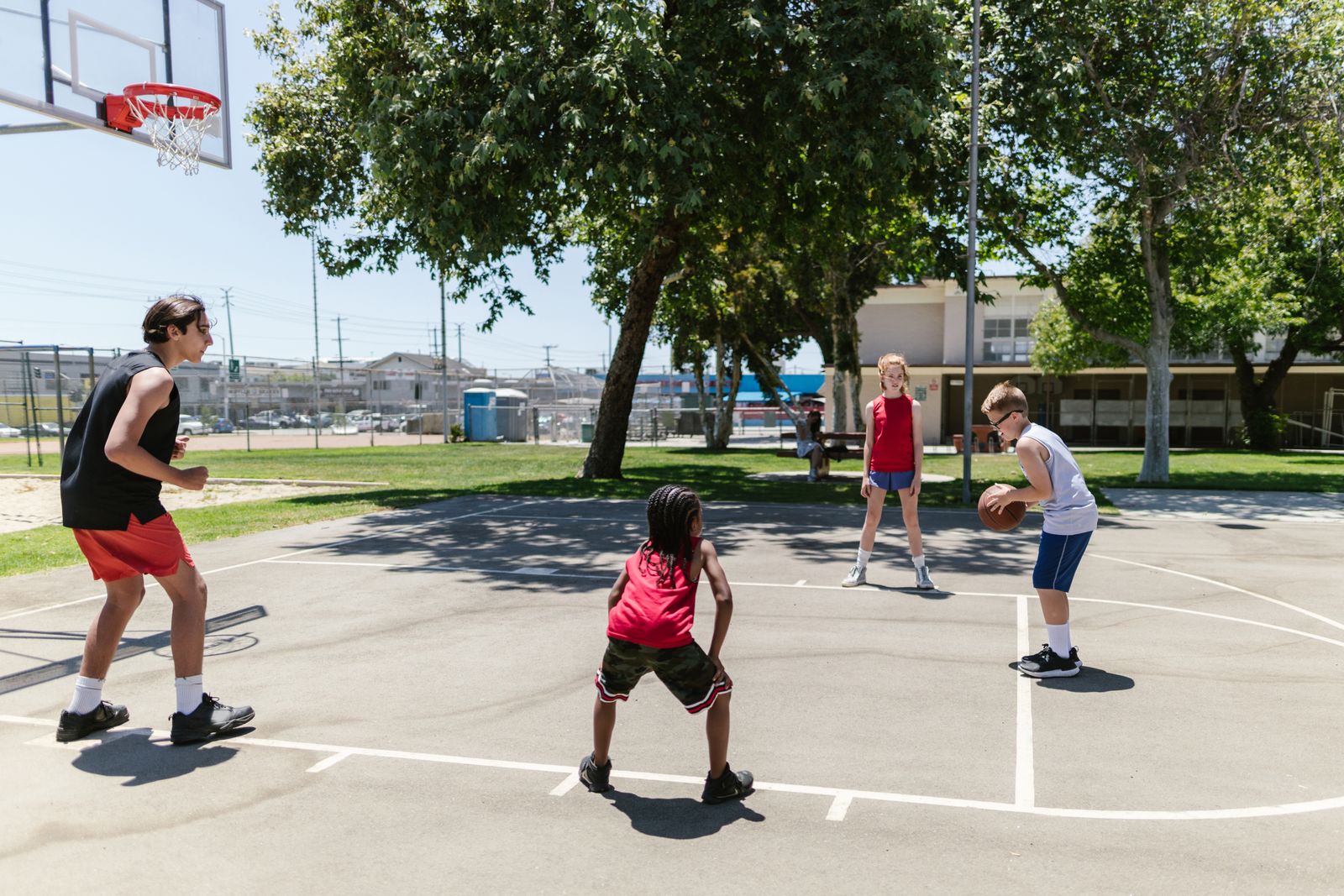 Children playing basketball together outdoors